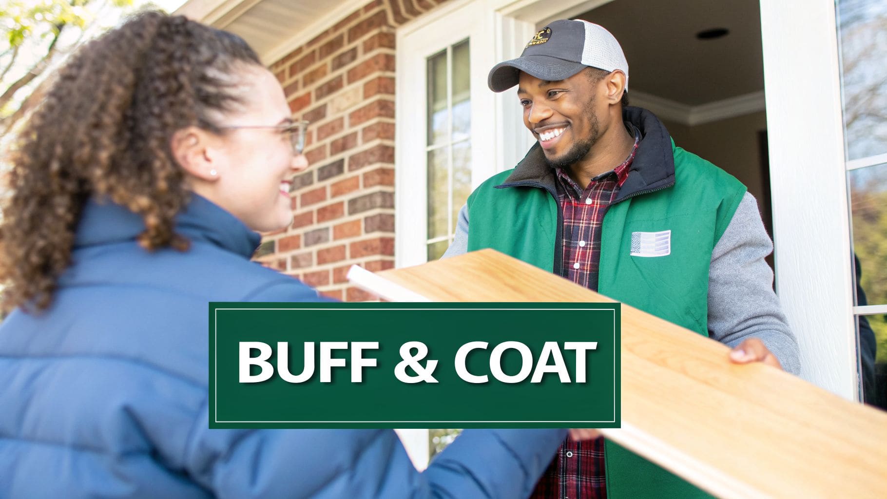 A smiling man, likely an installer, delivers wood planks to a happy woman at her doorstep.